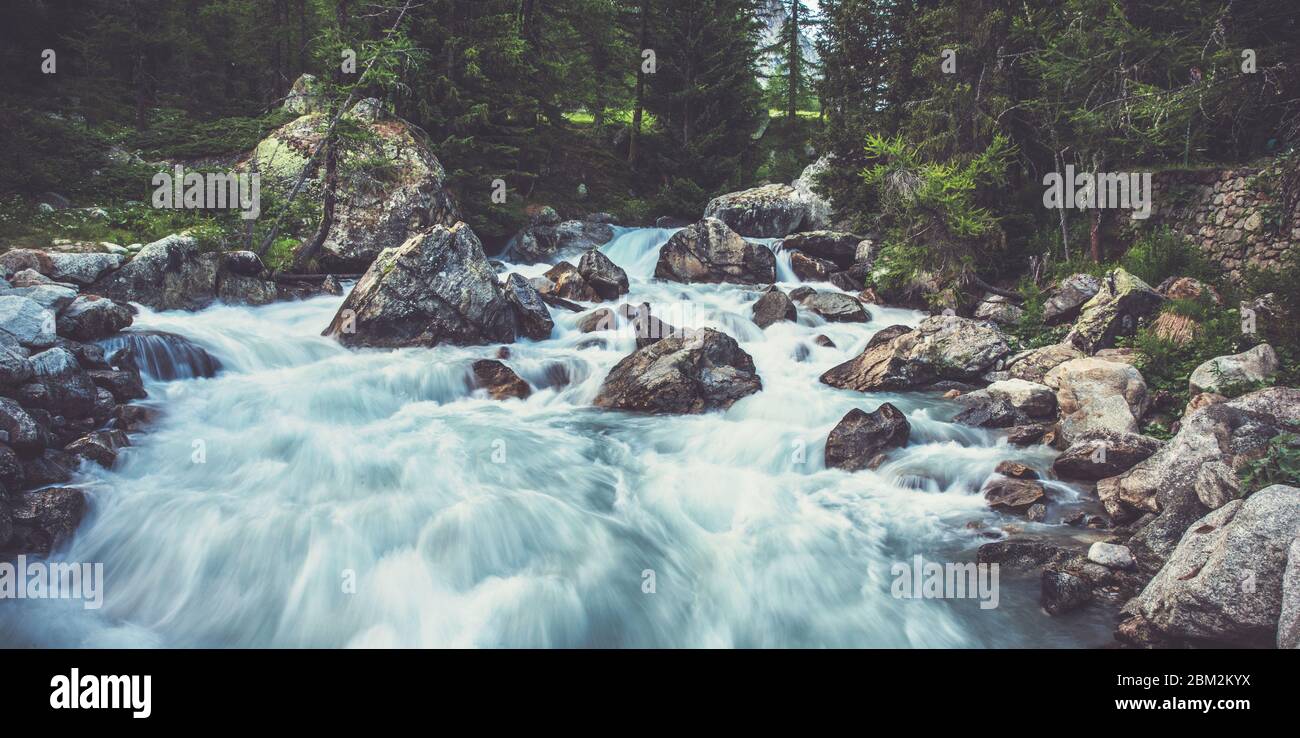 View Of Robust Water Flow In Small Stream With Boulders Trees And Forest Landscape. Stock Photo