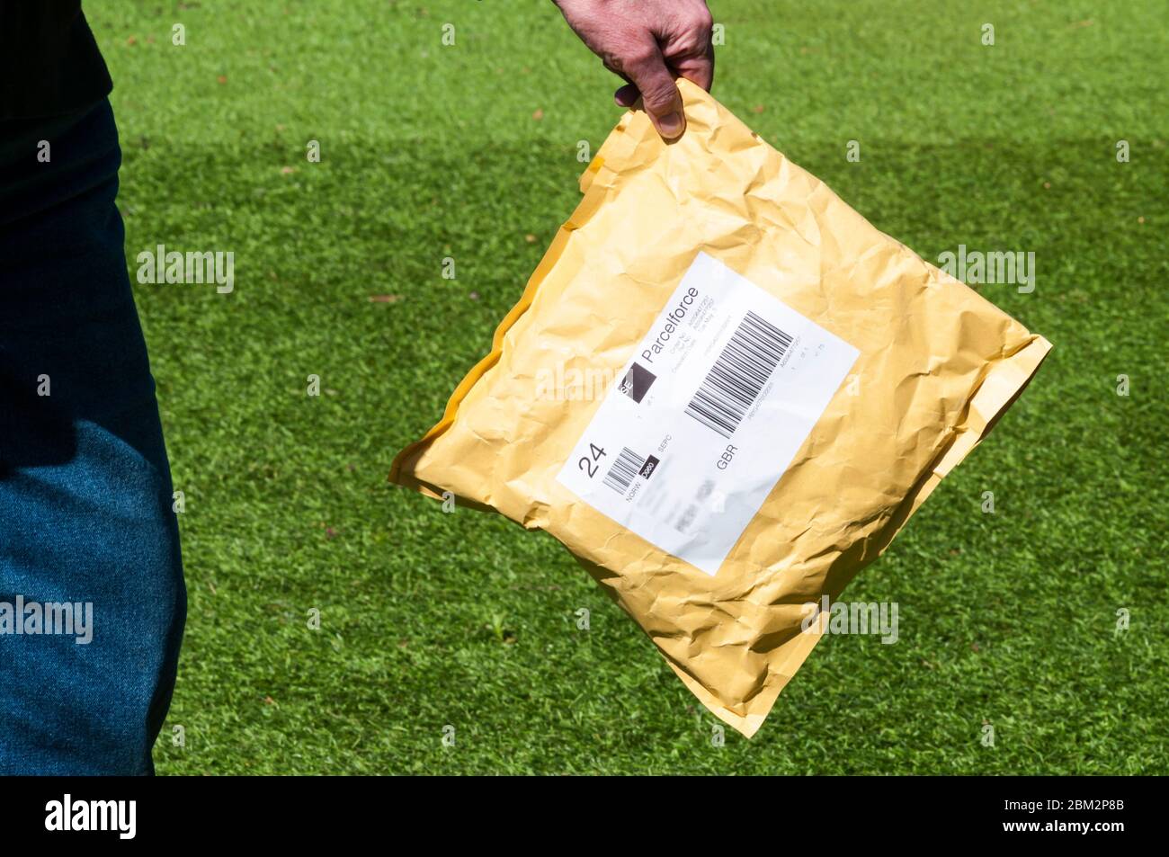 Woman holding a parcel delivery very carefully during 2020 COVID-19 Coronavirus pandemic. Stock Photo