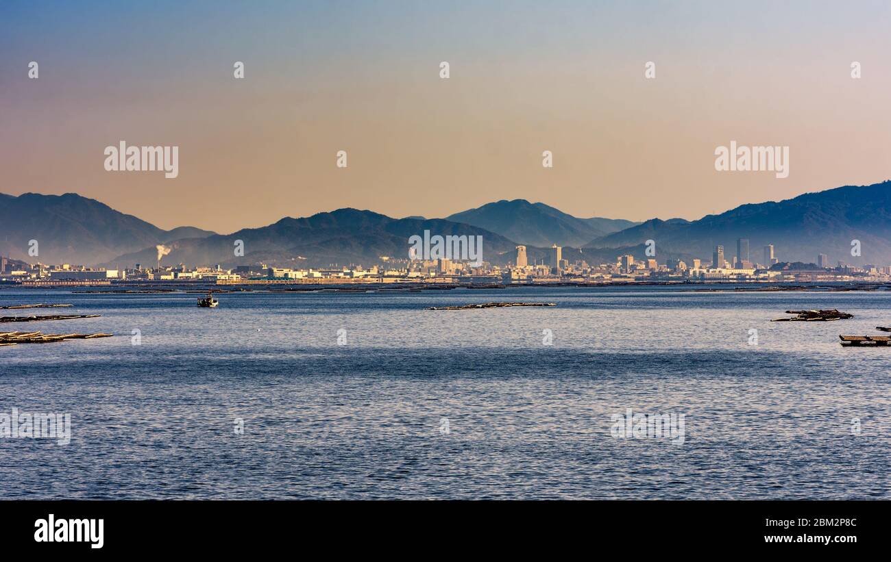 Scenic view of Hiroshima bay of the Seto Inland sea of Japan, with Hiroshima city in the distance, Japan Stock Photo