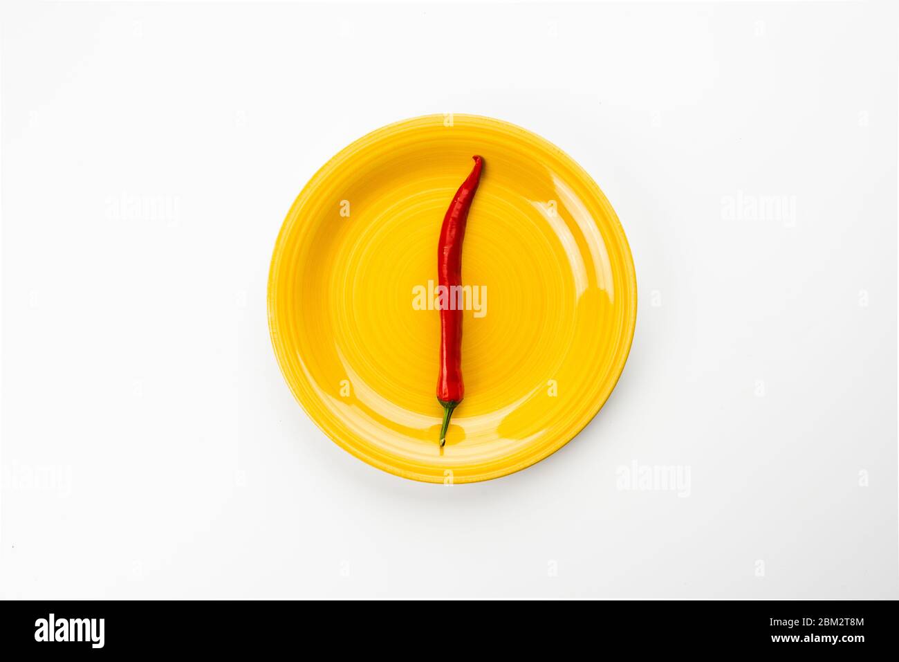 Yellow plate with red Chili pepper. Stock Photo