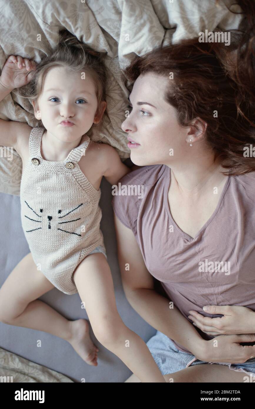 Mother cuddling daughter In bed Stock Photo - Alamy