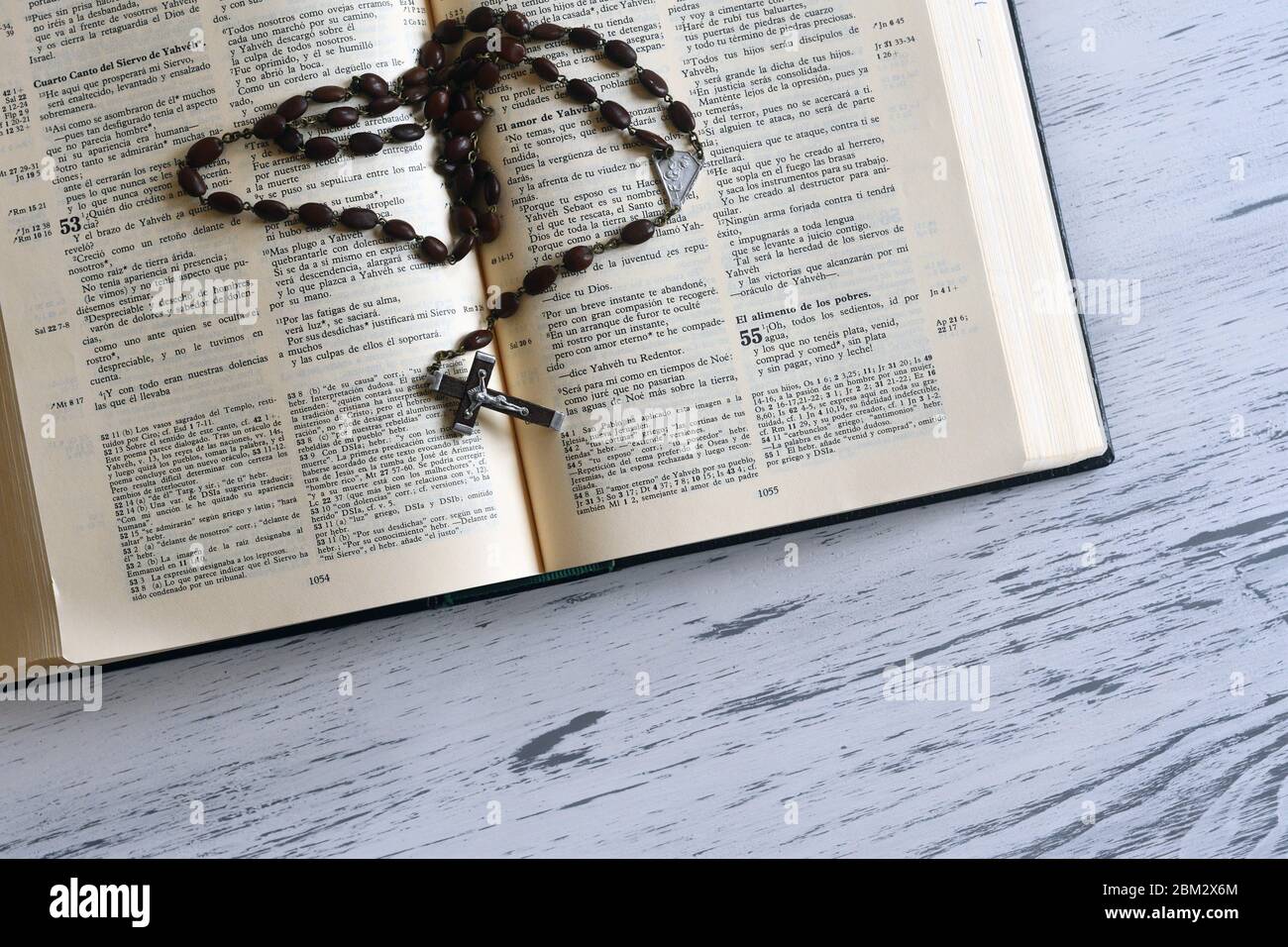 Wooden rosary over a Bible in a spanish edition Stock Photo