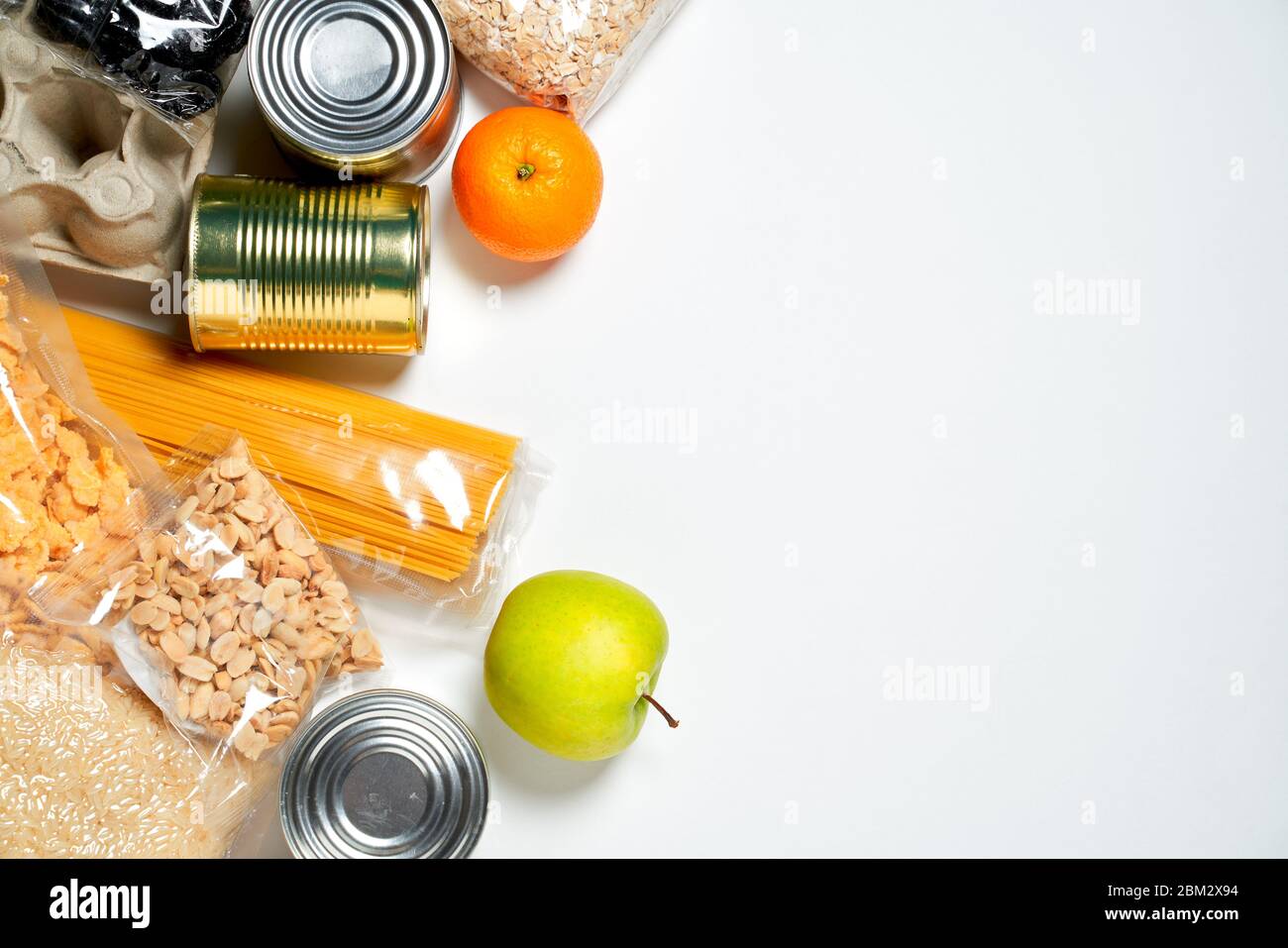 Various foods sealed in plastic bags, cans and fruits on white