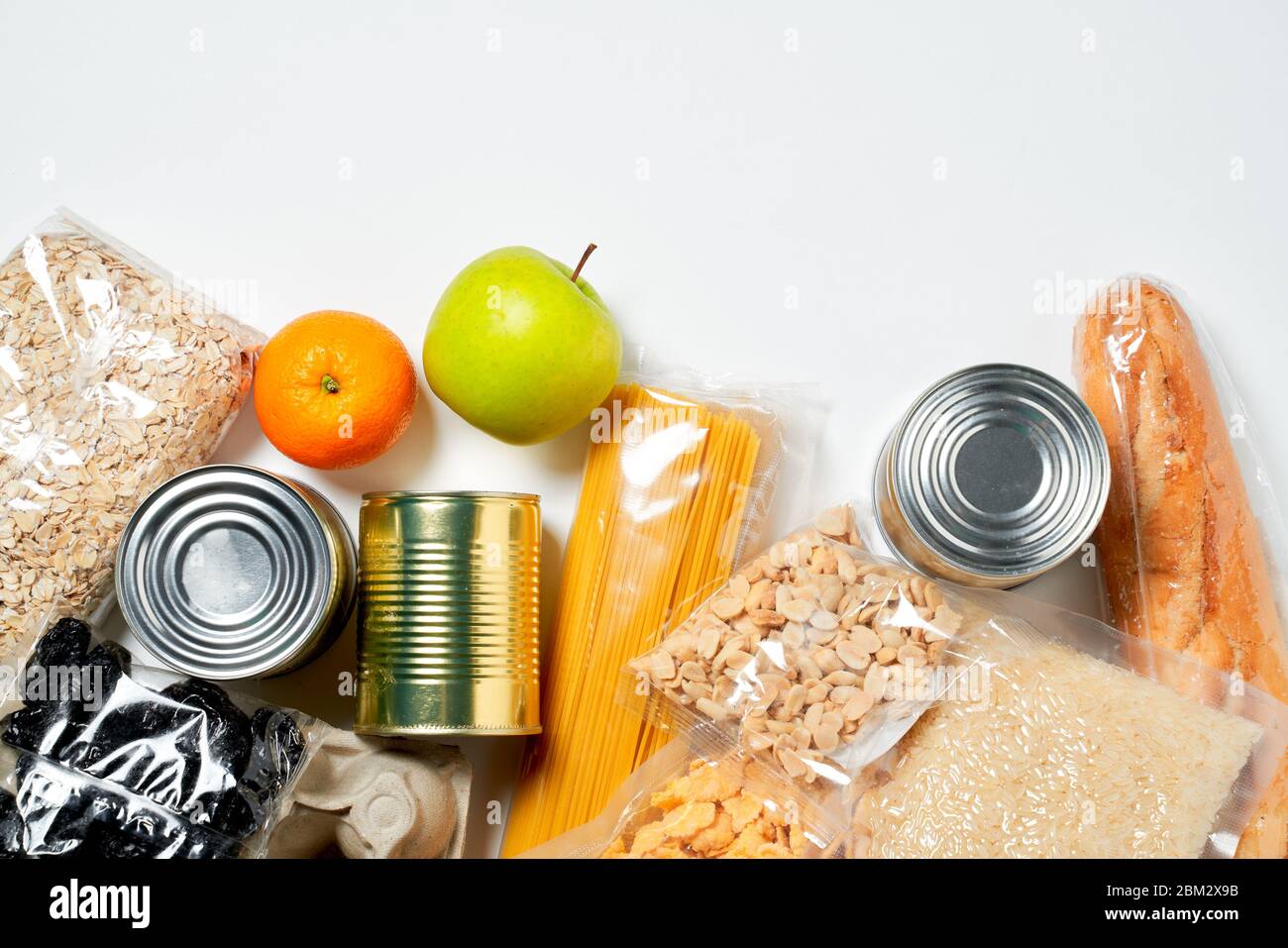 Various foods sealed in plastic bags, cans and fruits on white
