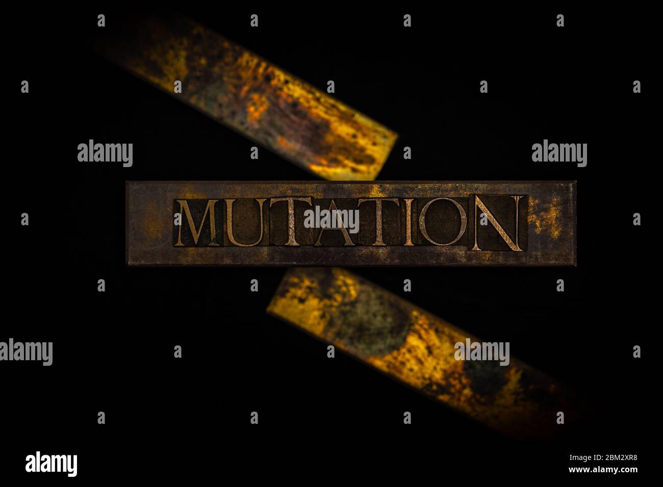 Photo of real authentic typeset letters forming Mutation text on vintage textured grunge copper and black background Stock Photo