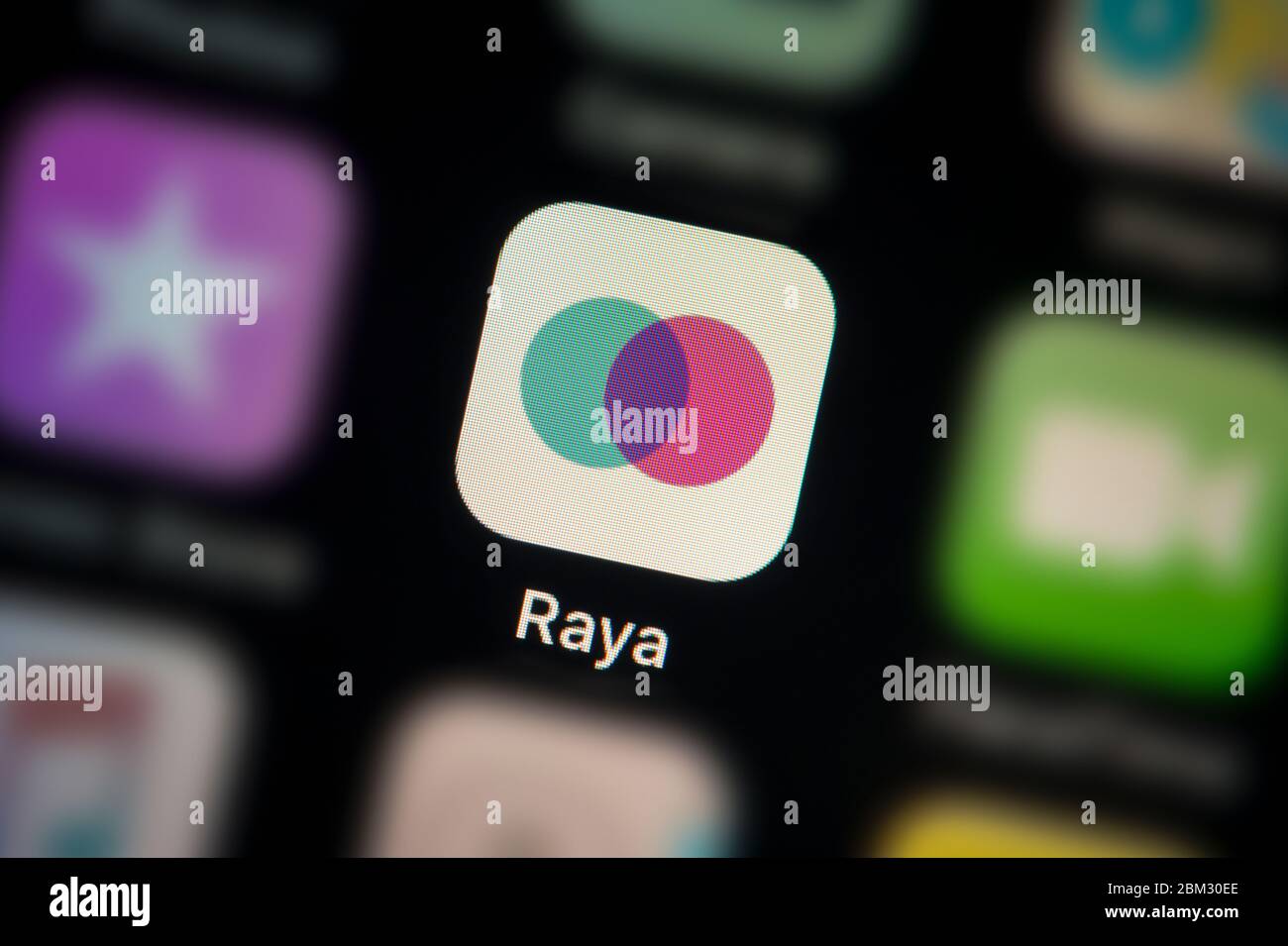 A close-up shot of the Raya app icon, as seen on the screen of a smart phone (Editorial use only) Stock Photo