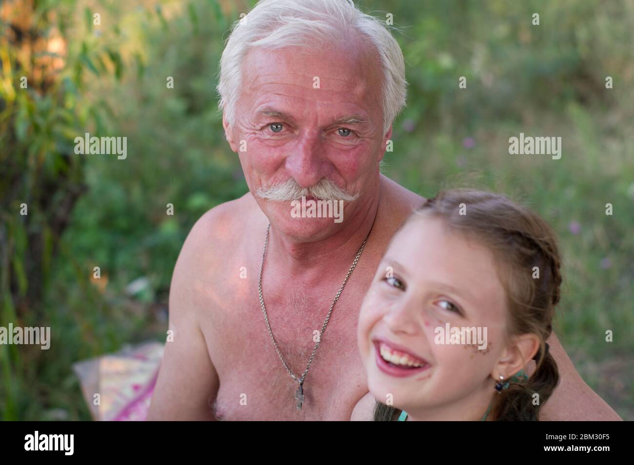 Grandfather have fun with granddaughter. Joyful grandfather and granddaughter. Handsome