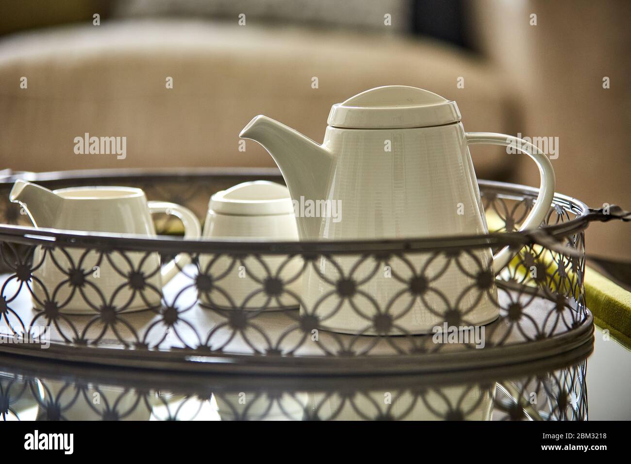 Shot of a white teapot and teacup on a tray Stock Photo