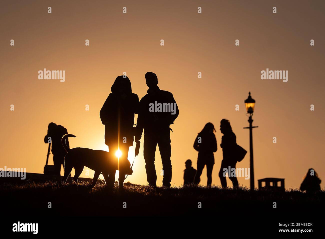 People wait for the moon to rise over Primrose Hill in central London, ahead of the final supermoon of the year, which will be visible over the UK on Thursday evening. The full moon in May is also known as the 'flower moon', signifying the flowers that bloom during the month. Stock Photo