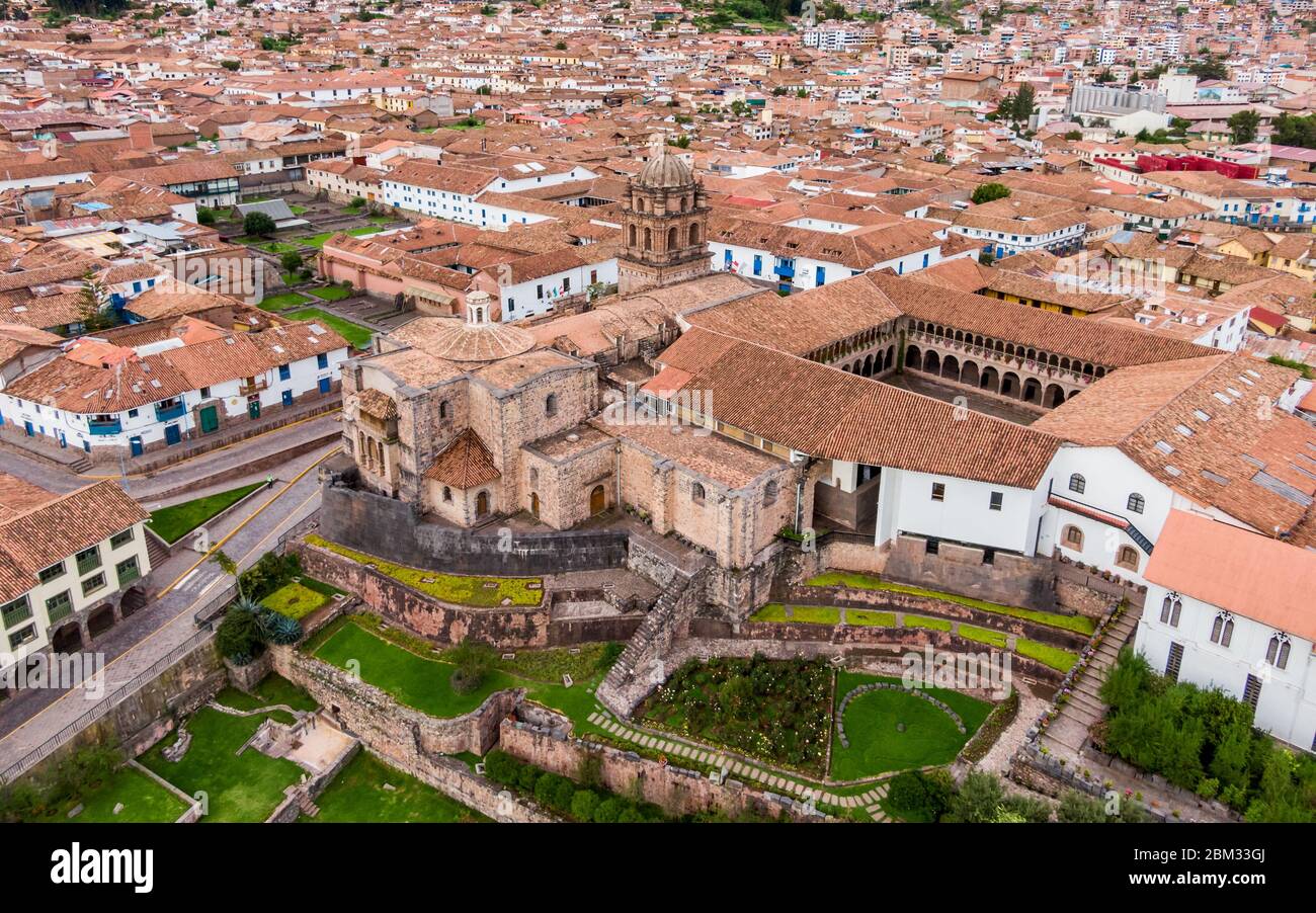 Aerial side view over empty Qorikancha gardens, Inca temple of the Sun in Cusco, and the empty streets of the city because of Coronavirus Stock Photo