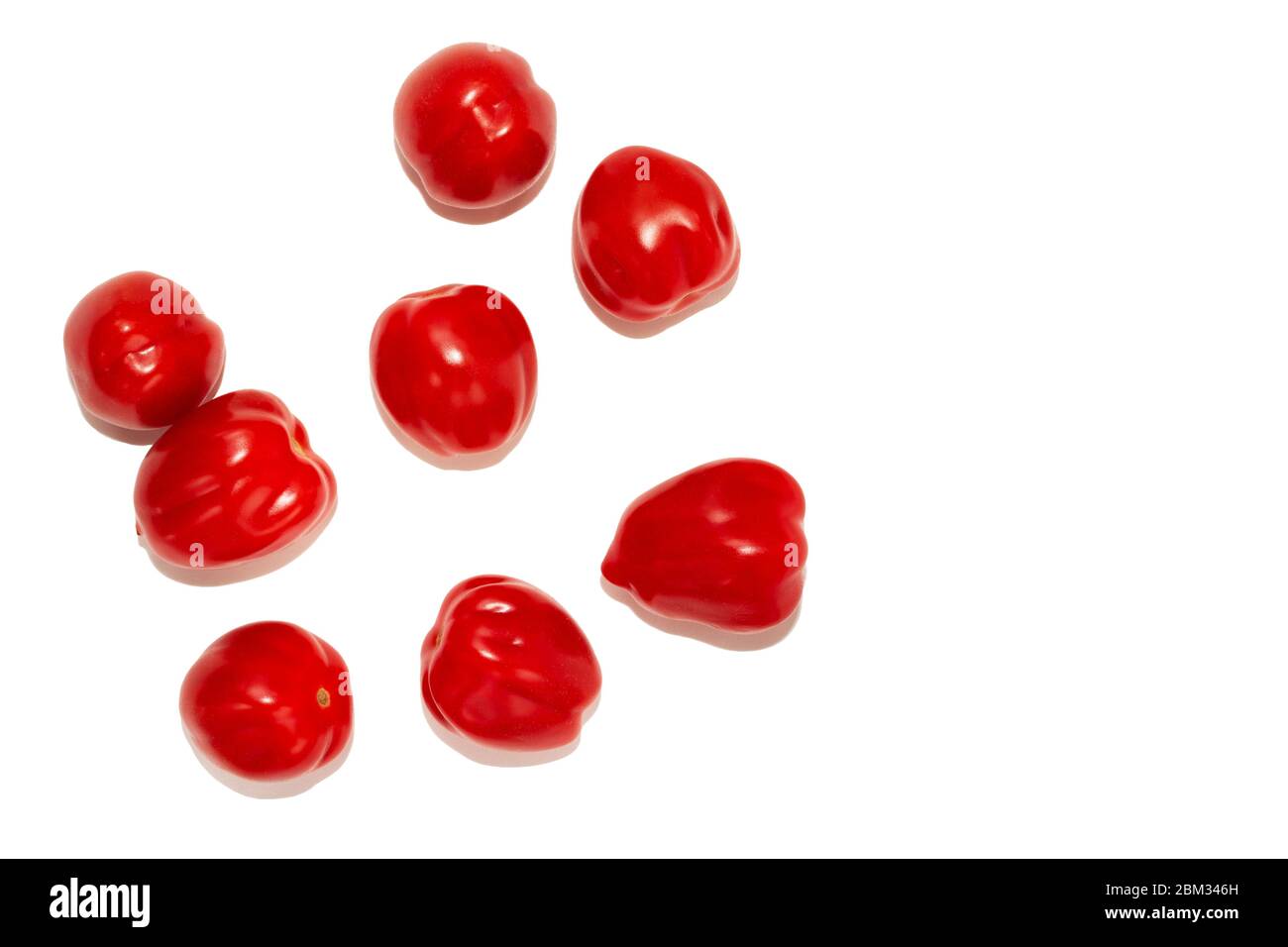 So-called elongated tomatoes, laid one near the other, isolated on a white background. Lots of red small uncut elongated cherry tomatoes top view Stock Photo