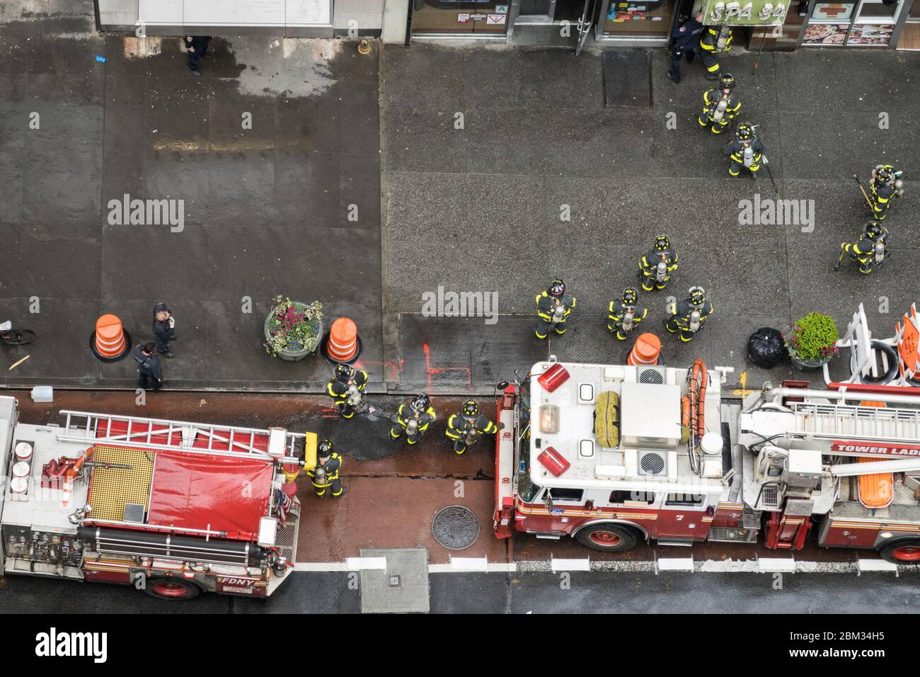 FDNY firemen in full turnout gear respond to an alarm in Midtown Manhattan, NYC, USA Stock Photo