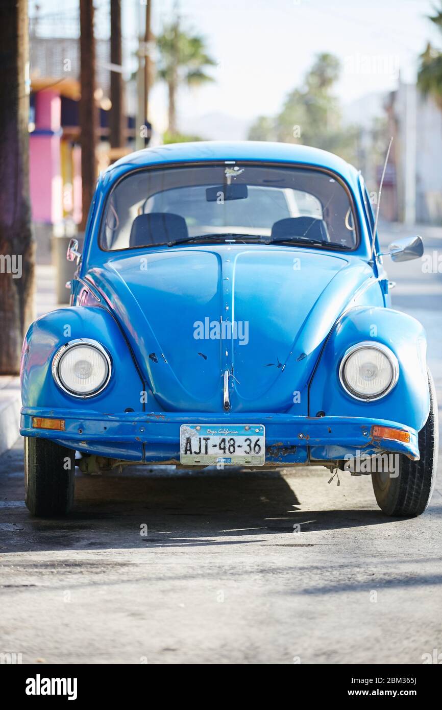 An old Volkswagen Beetle is parked on a colorful street in Cabo San Lukas, Mexico Stock Photo