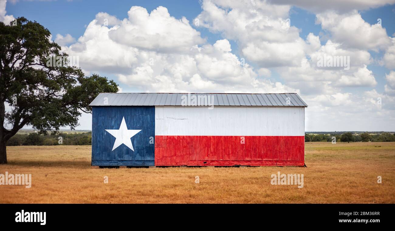 Texas flag painted on old barn. American farmers background, rural scene. Stock Photo