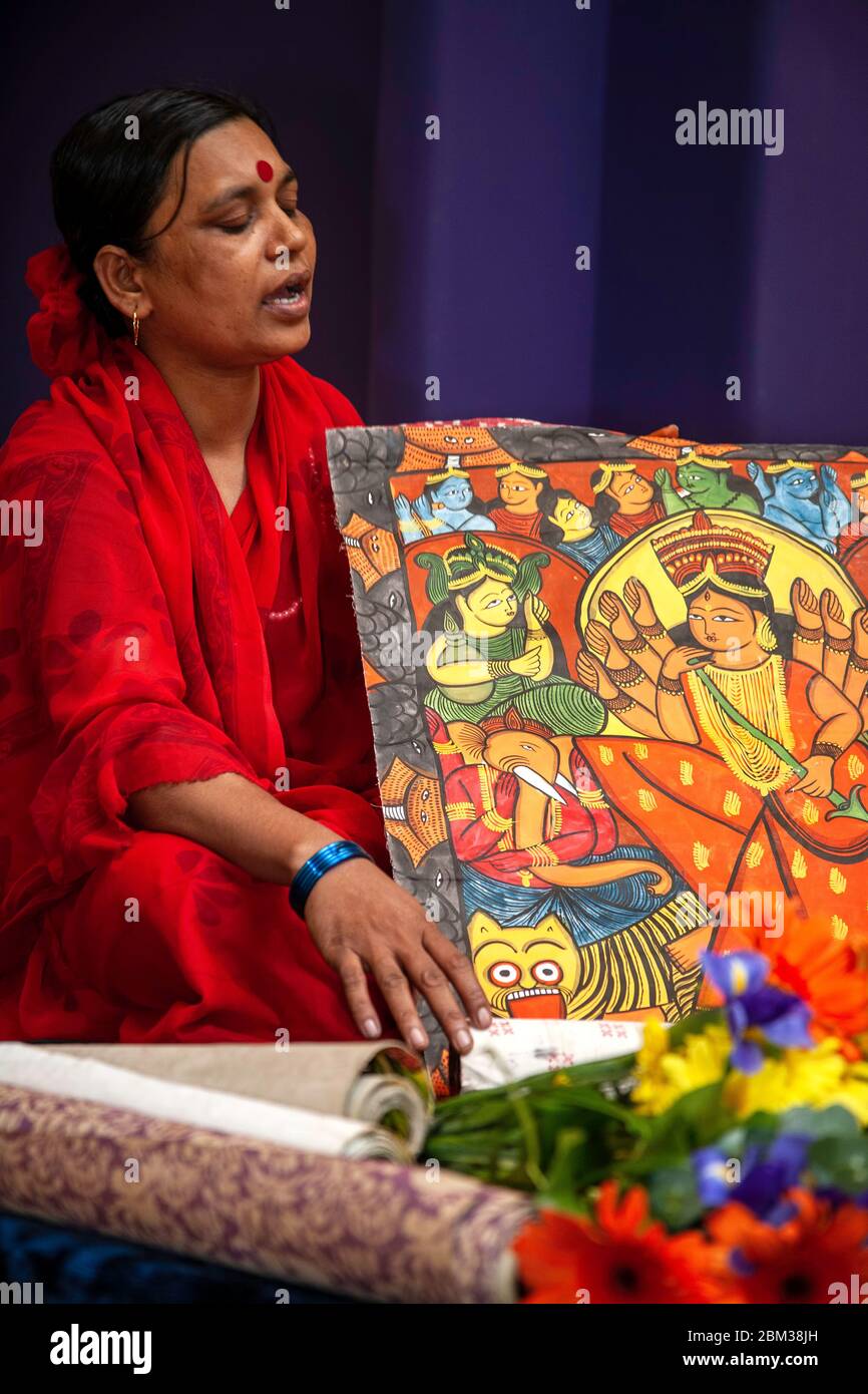 Swarna Chitrakar unrolling painted scroll as she sings, Village of Painters Exhibit, Museum of