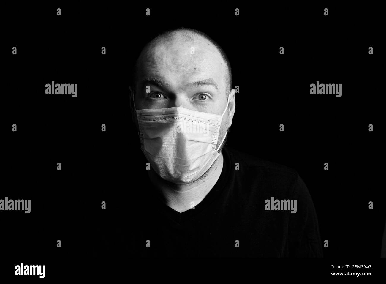 Person in medical face mask on black background. Portrait of a man in a ...