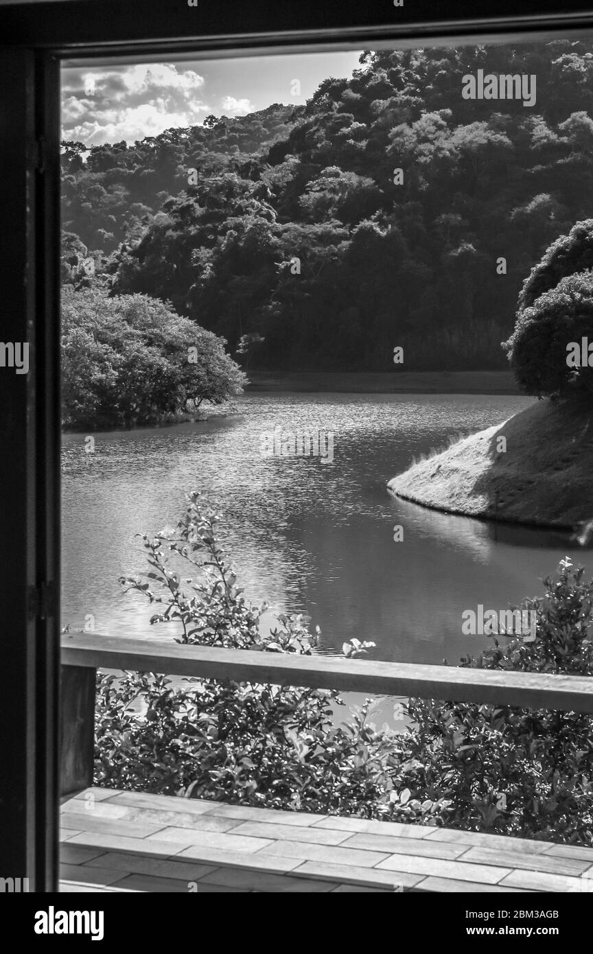 Large dark water lake, with a lot of forest around it, seen through the window, Barra do Pirai, Rio de Janeiro, Brazil Stock Photo