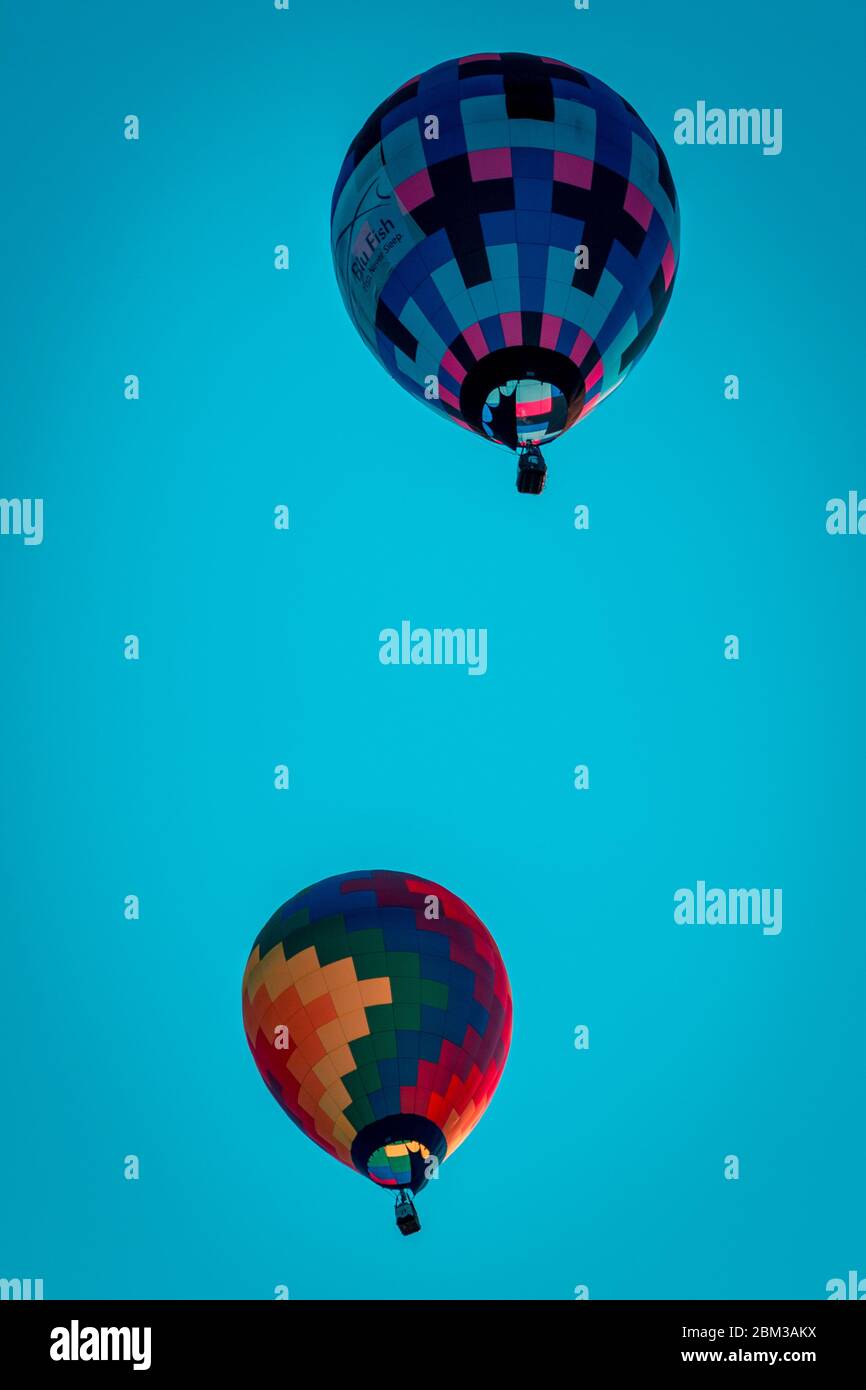 Hot air balloons flying by in a clear blue sky Stock Photo - Alamy