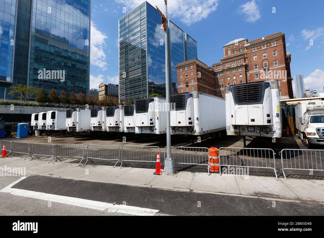 Temporary refrigerated trucks parked behind the NYC medical examiners main facility for Covid-19 victims Stock Photo