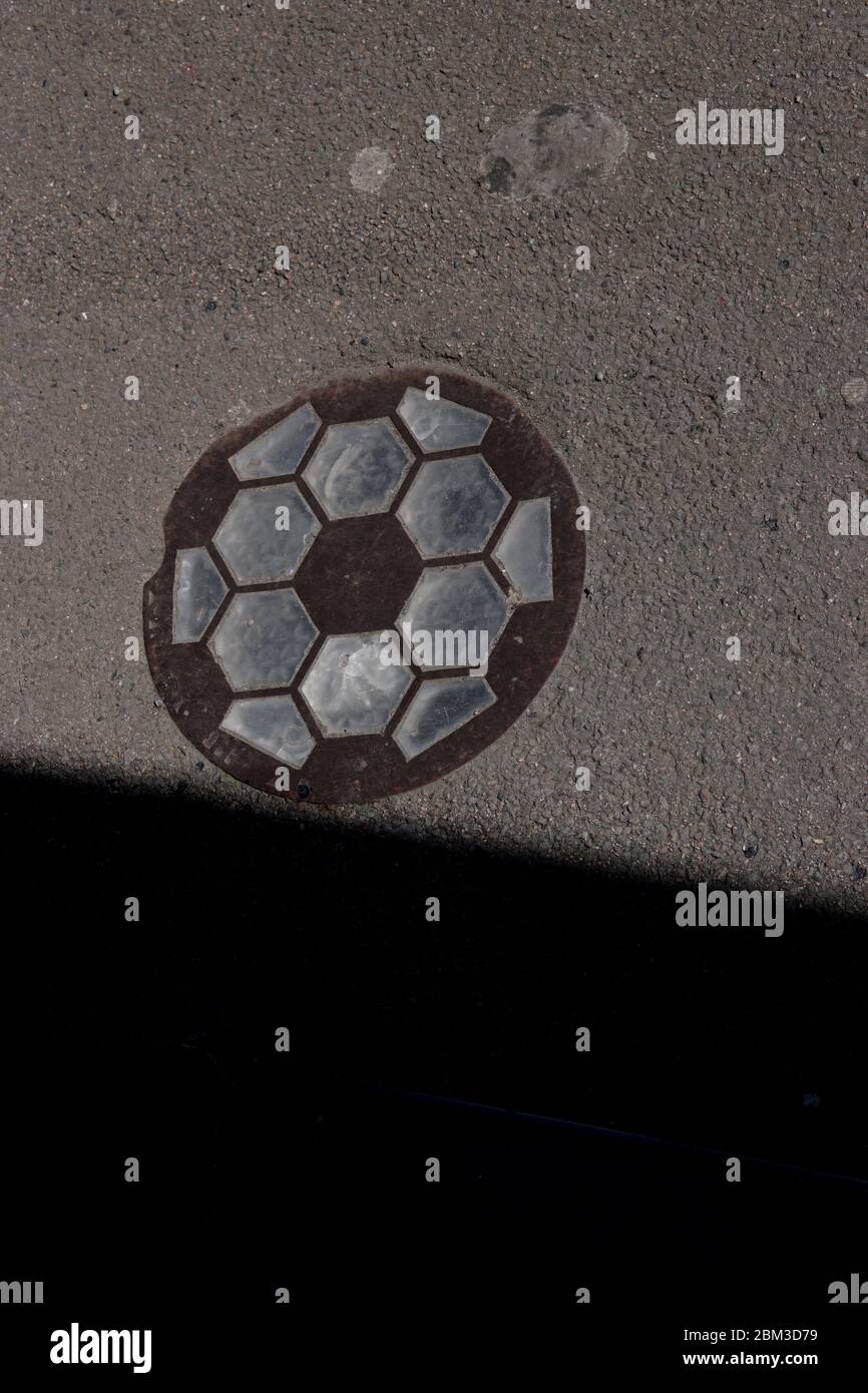 A Hexagon Glass Insert, Showing the Round Pavement Skylight Embedded in Tarmac with the Original Iron Grid, with Natural Grit and Dirt in the Shadow. Stock Photo