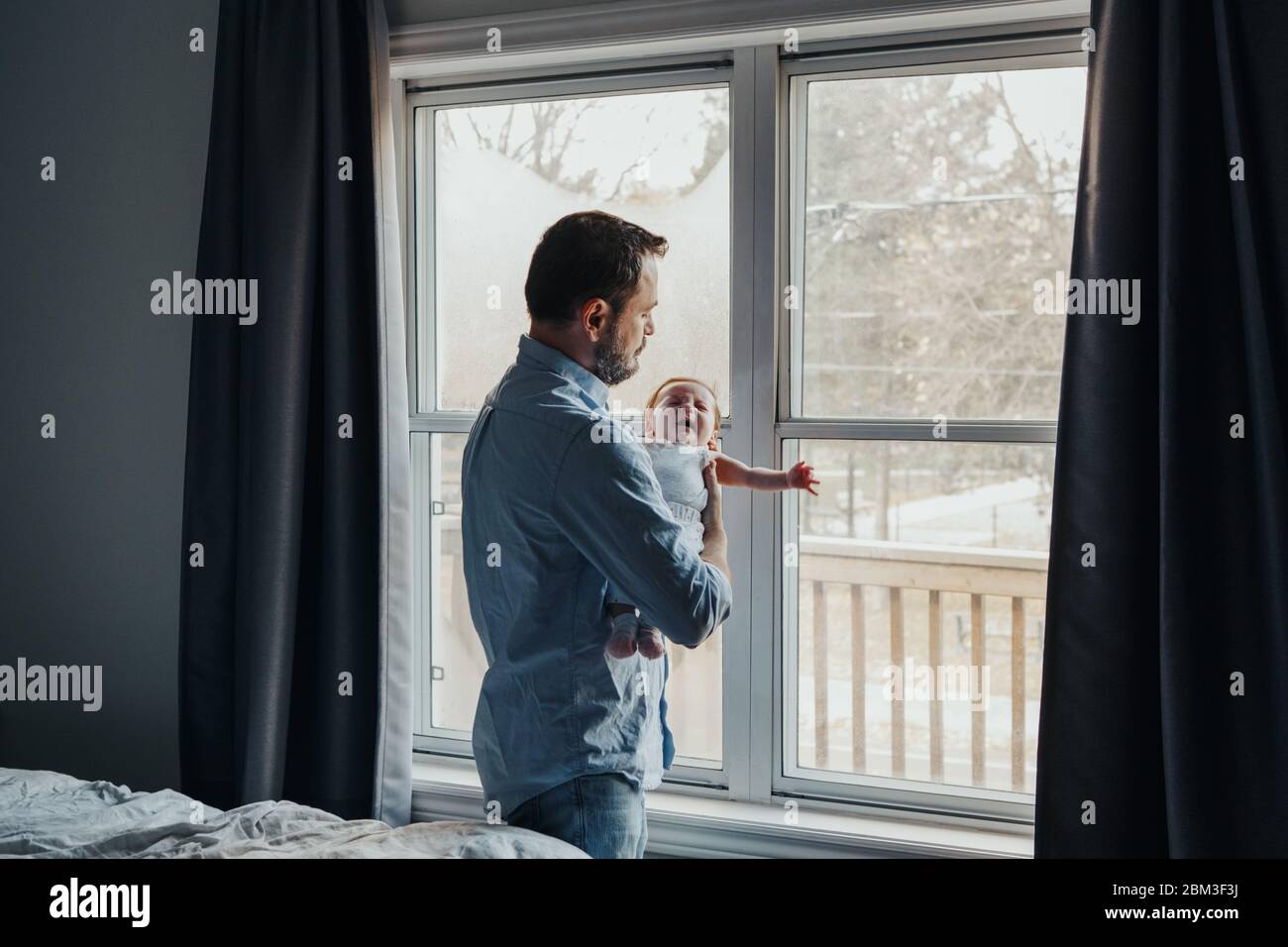 Middle age Caucasian father trying to calm down newborn baby. Man ...
