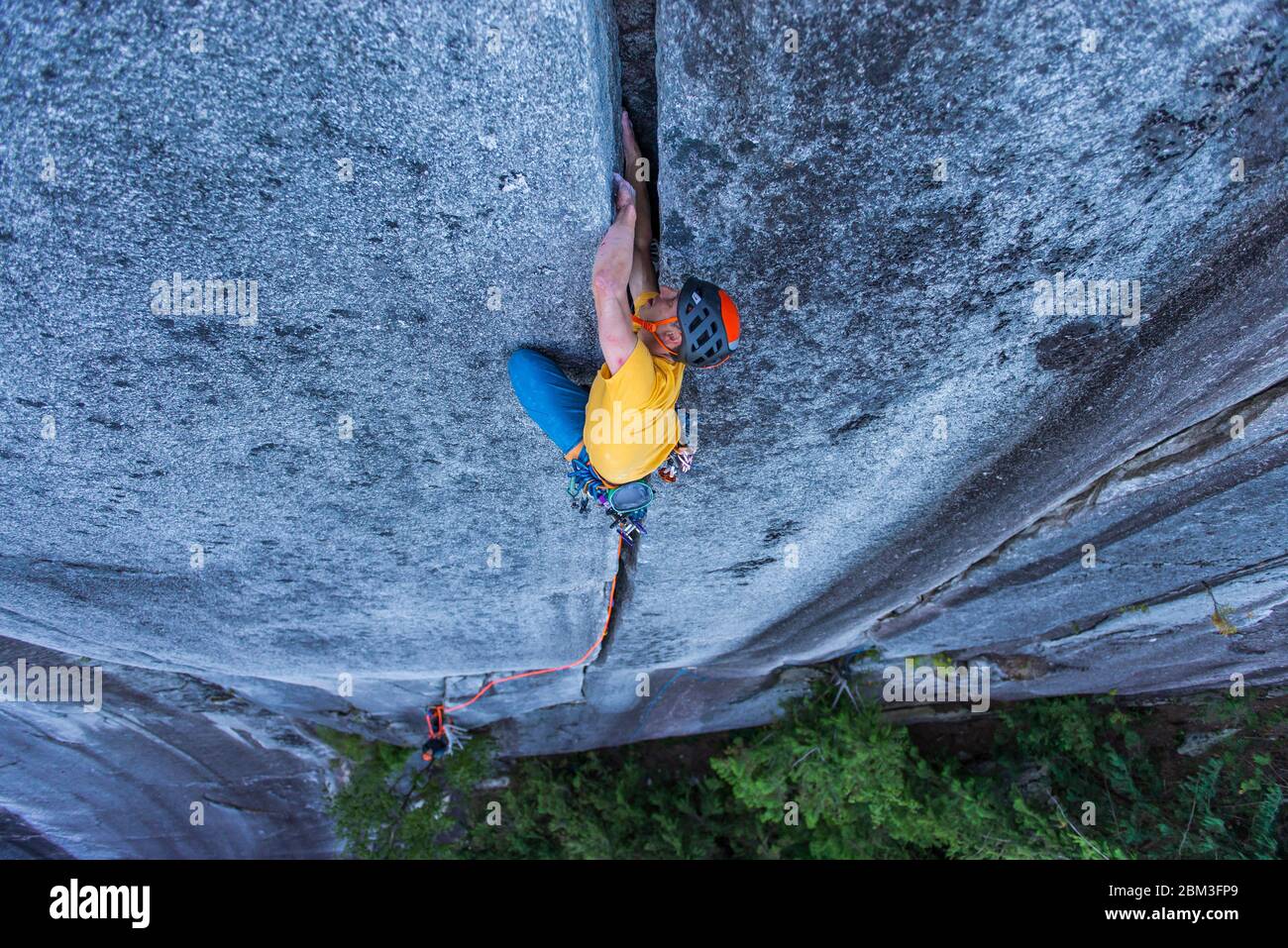 man lead climbing off width granite climb in Squamish Canada BC Stock Photo