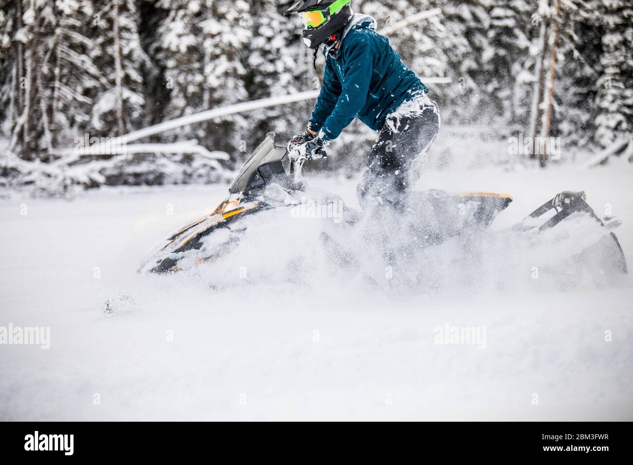 Side view of man snowmobiling through deep snow Stock Photo Alamy