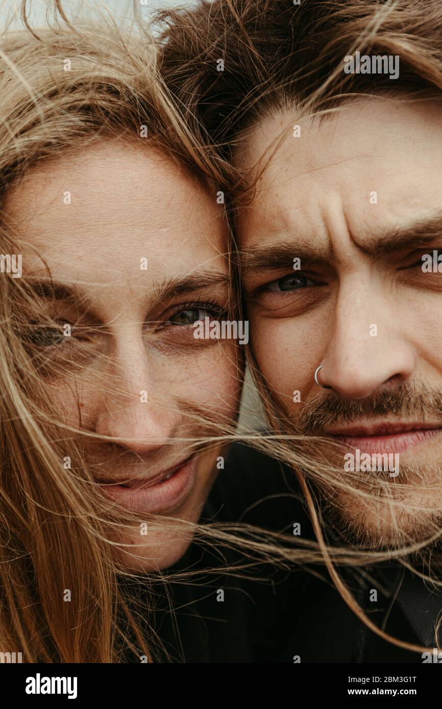 up close of man and woman with eyes next to each other and windy hair Stock Photo