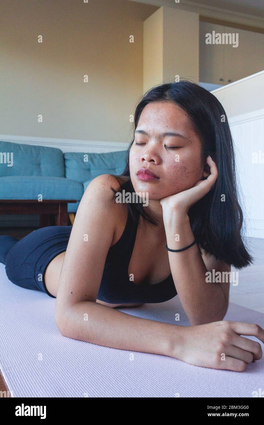 Young woman resting on mat yoga after practicing yoga Stock Photo