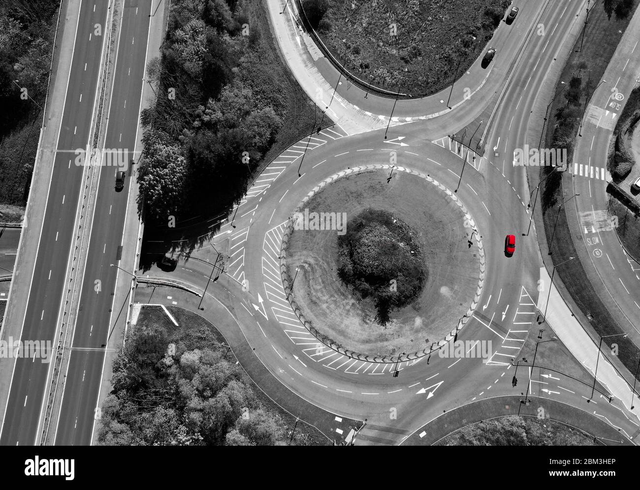 Aerial overhead view of roundabout in monotone with red car Stock Photo