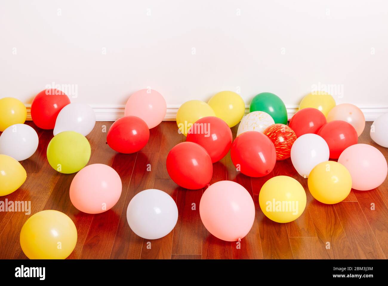 Group of many colorful air balloons lying on floor in studio apartment