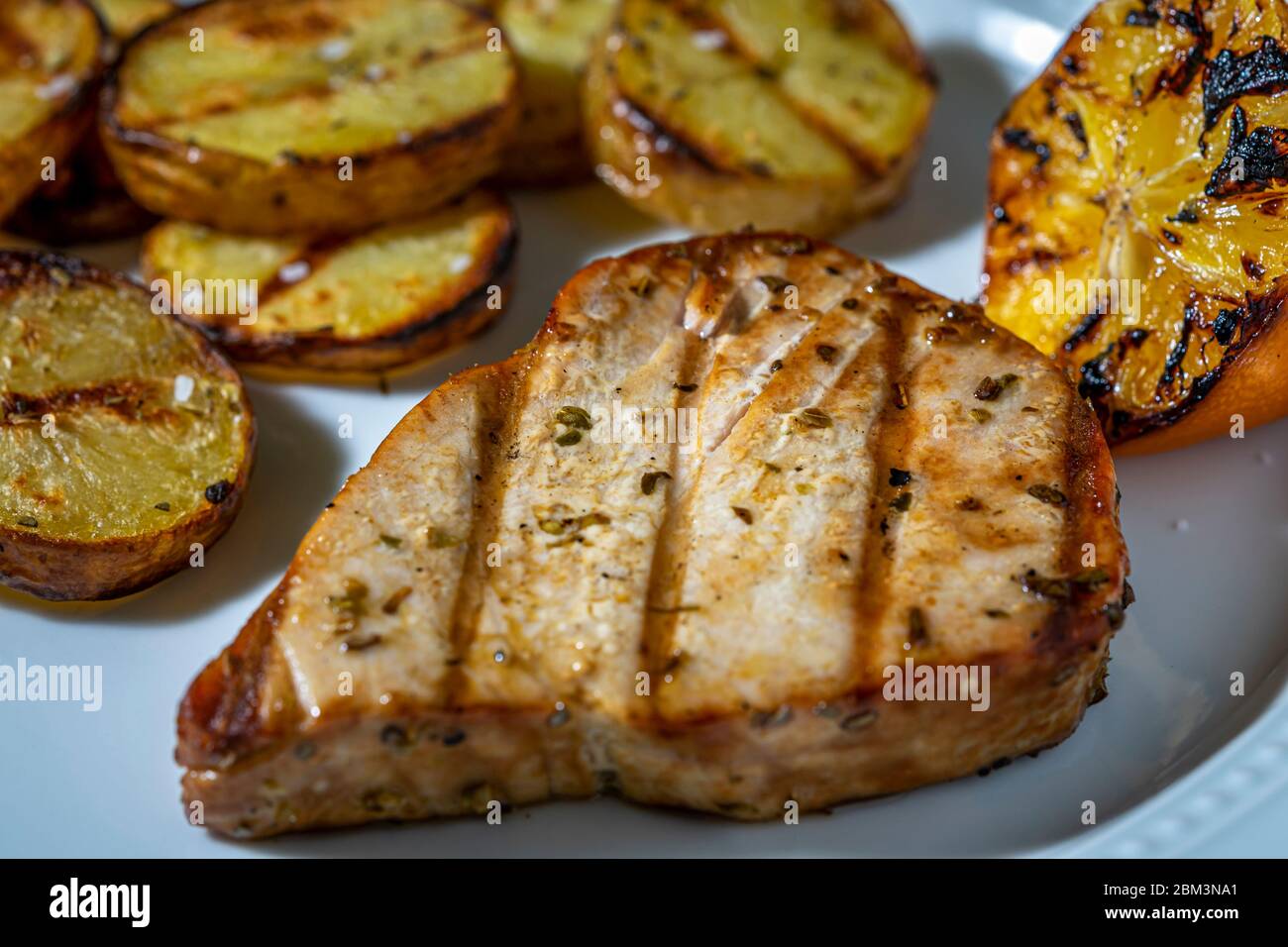 Grilled tuna steak and grilled potato rounds Stock Photo Alamy