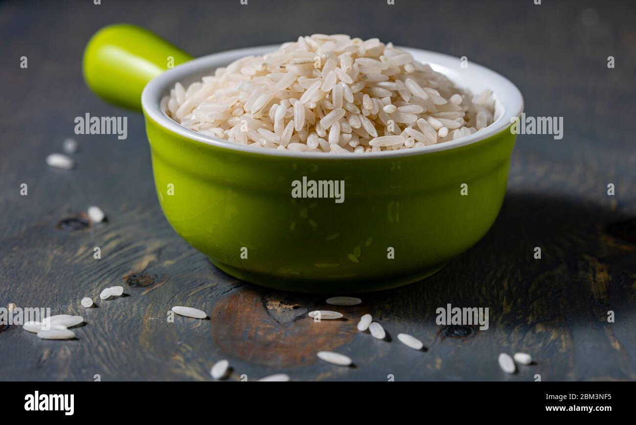 White rice in ceramic measure cup. Stock Photo