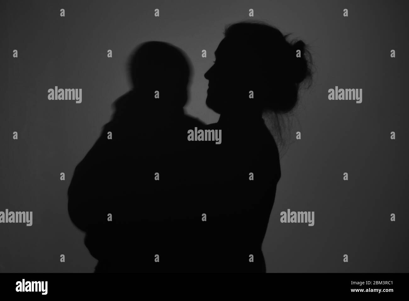 Silhouette Of Happy Mother and Baby. Mom smiling to baby, Happy Mother's Day concept Stock Photo