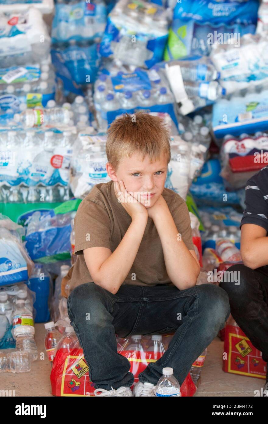 Young residents of Bastrop, Texas at the Convention Center sit if front of donated bottled water after massive wildflowers swept the area in early September, 2011  September 9, 2011.  ©Marjorie Kamys Cotera / Daemmrich Photos Stock Photo