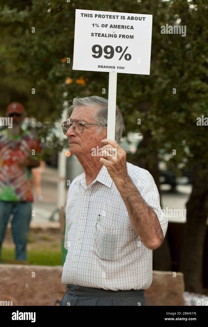 Austin, Texas USA, October 6, 2011: An elderly man holding a protest sign is part of a small crowd at an Occupy Austin demonstration at City Hall. Occupy Austin is an offshoot of Occupy Wall Street, an ongoing protest that denounces the role that large companies play in the current financial crisis. ©Marjorie Kamys Cotera/Daemmrich Photography Stock Photo