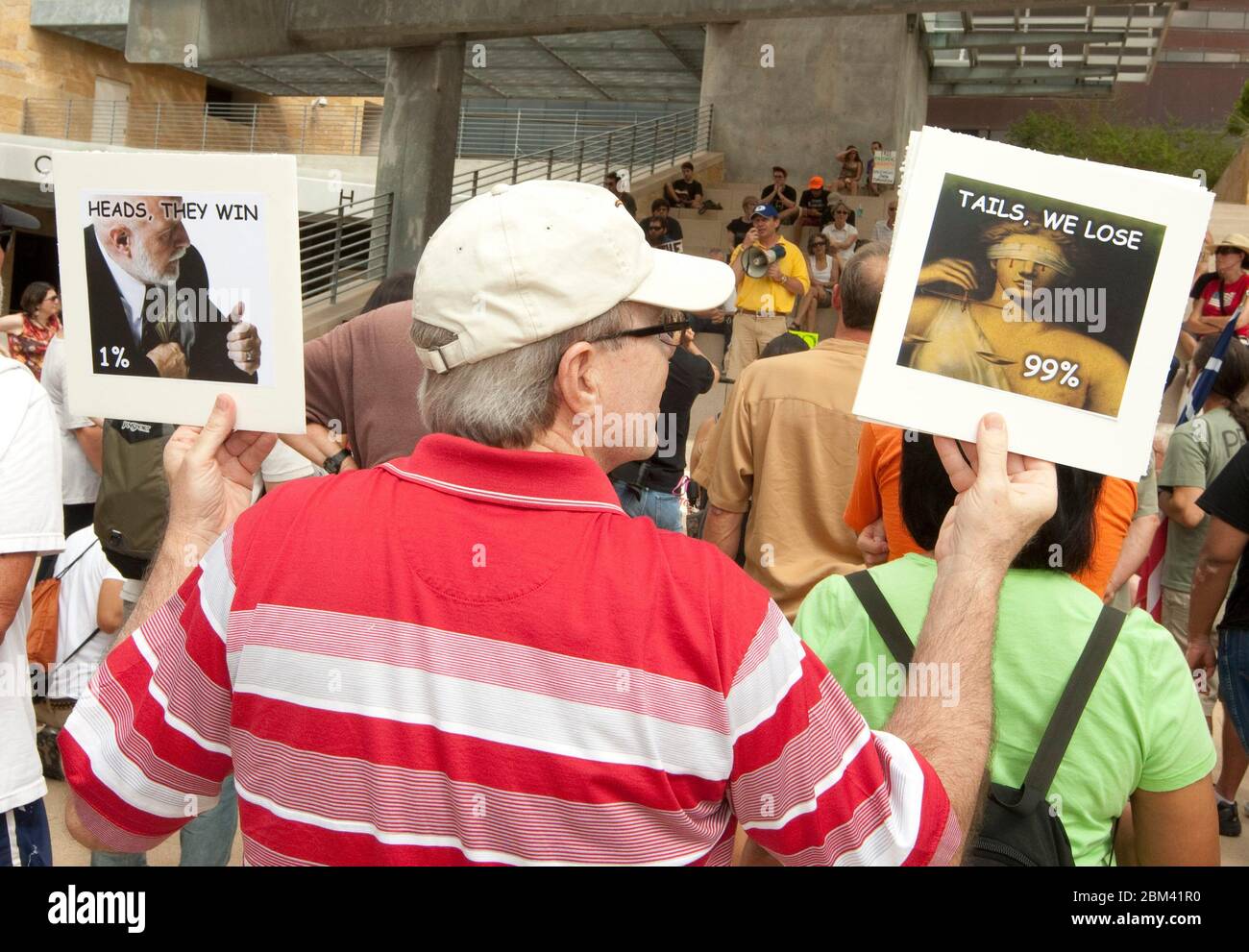 Austin, Texas USA, October 6, 2011: A man holding depictions of the wealthy 1% of Americans and the unfortunate 99% with less money and power joins a small crowd at an Occupy Austin demonstration at City Hall. Occupy Austin is an offshoot of Occupy Wall Street, an ongoing protest that denounces the role that large companies play in the current financial crisis. ©Marjorie Kamys Cotera/Daemmrich Photography Stock Photo