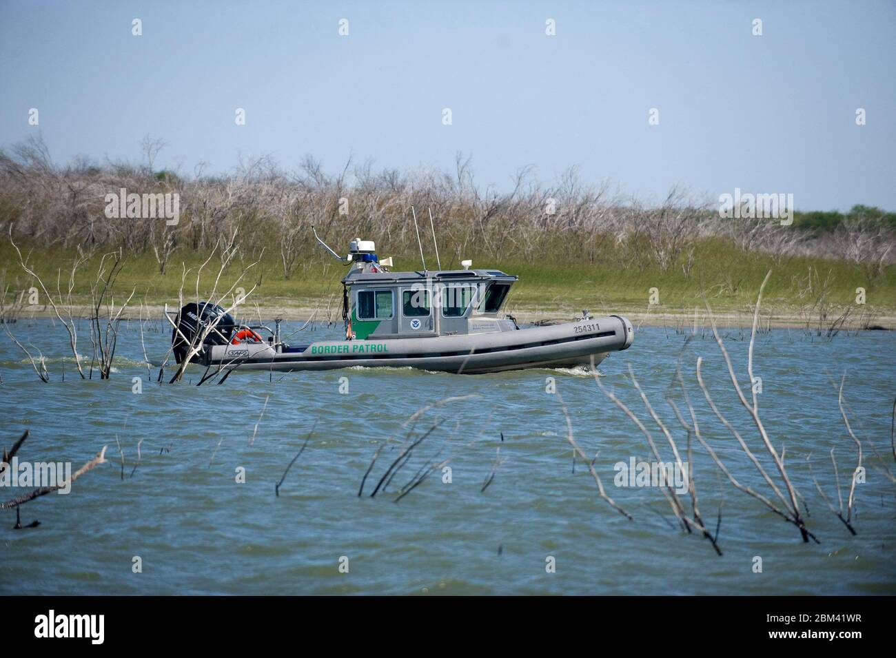 Falcon Lake Texas USA, October 2011: A United State Border Patrol boat idles through Big Tiger Cove on Falcon Lake on the U.S. side of the border between Texas and Mexico south of San Antonio. A haven for bass fishermen, Falcon Lake has seen a rise in confrontations between alleged Mexican drug cartel operatives and fishermen since the killing of a U.S. citizen on the Mexican side in 2010. ©Bob Daemmrich Stock Photo