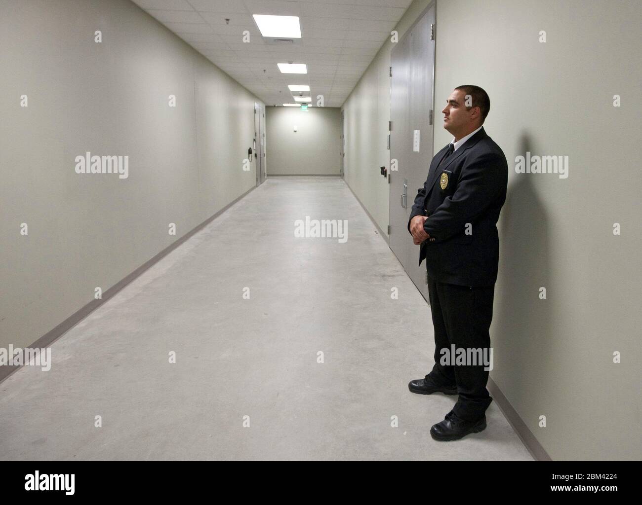 Bastrop Texas USA, November 10 , 2011: Security guard stands in empty hallway at electric power management facility. ©Marjorie Kamys Cotera/Daemmrich Photography Stock Photo