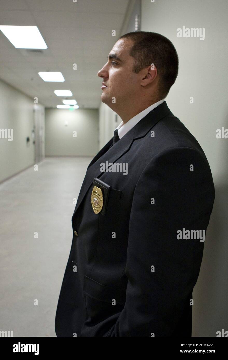 Bastrop Texas USA, November 10 , 2011: Security guard stands in empty hallway at electric power management facility. ©Marjorie Kamys Cotera/Daemmrich Photography Stock Photo