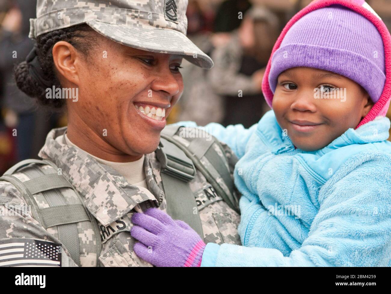 Fort Hood Texas USA, December 24, 2011: Black female Army war veteran smiles at daughter after arriving home from deployment in Iraq on Christmas Eve:  ©Marjorie Kamys Cotera/Daemmrich Photography Stock Photo