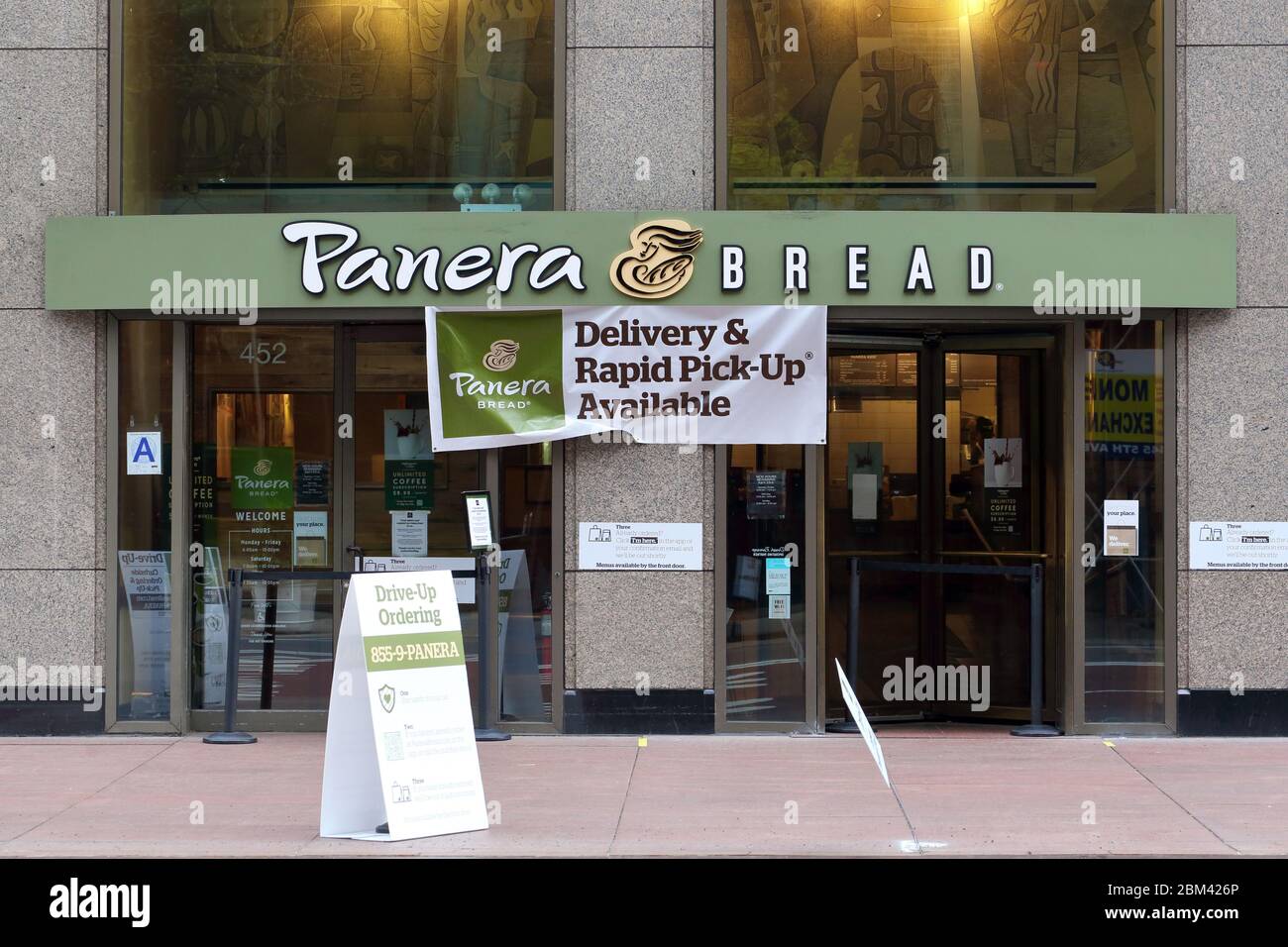 A Panera Bread in New York with signage announcing it is open for pickup and delivery (but not take-out) during the coronavirus COVID-19 crisis. Stock Photo