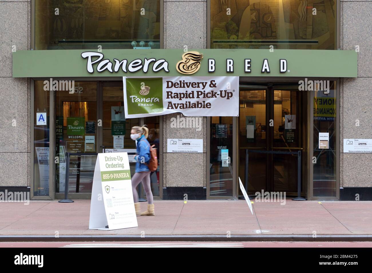 A Panera Bread in New York with signage announcing it is open for pickup and delivery (but not take-out) during the coronavirus COVID-19 crisis. Stock Photo