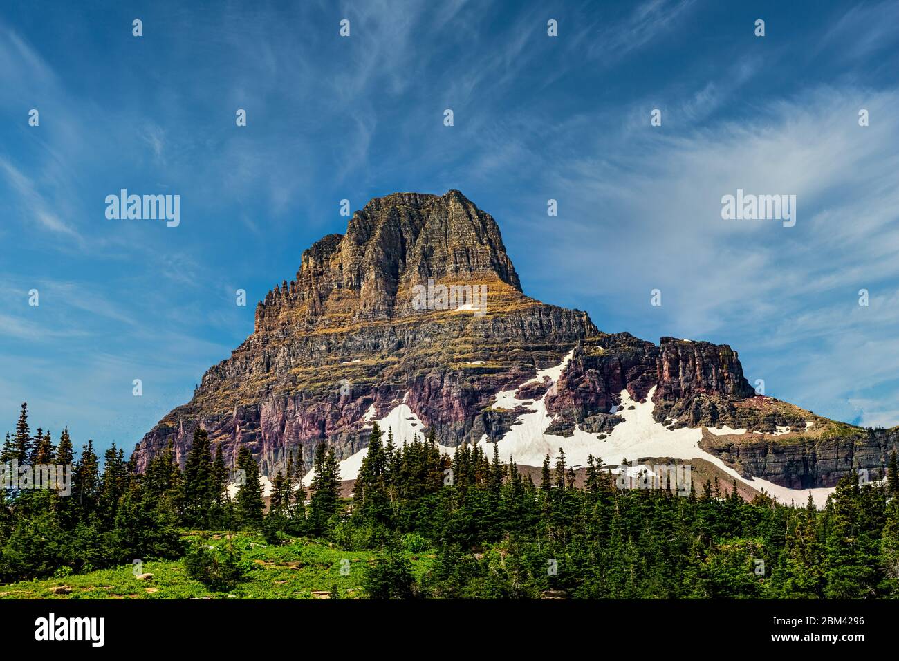 4836 Sunny day with wispy clouds in a blue sky above Clements Mountain. Viewed from the High Line Trail at Glacier National Park - Montana Stock Photo
