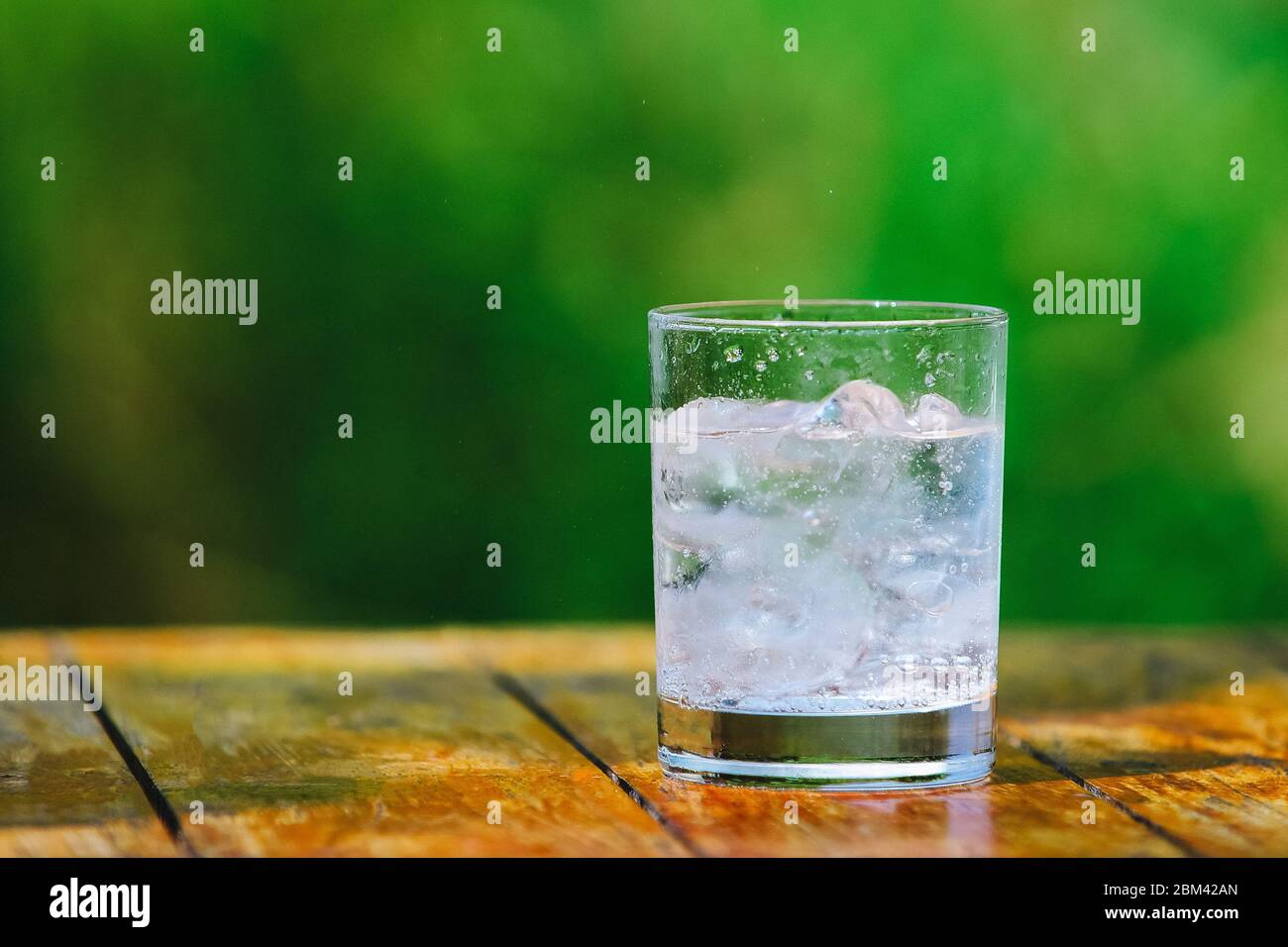 A glass of water with ice on green background. Mineral water Stock ...