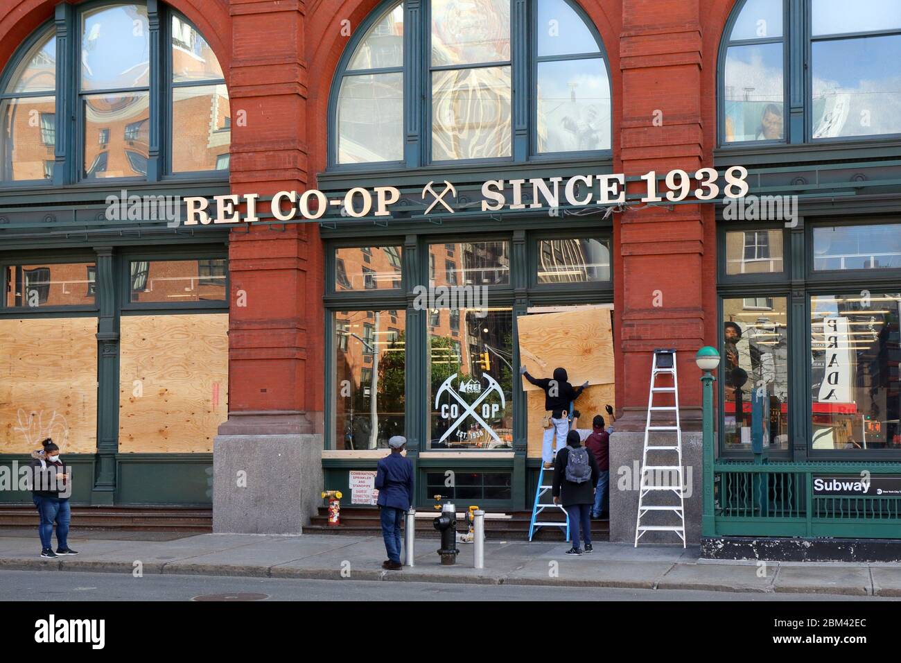 Workers boarding up the REI Flagship store in New York during the coronavirus COVID 19 crisis... SEE MORE INFO FOR FULL CAPTION Stock Photo