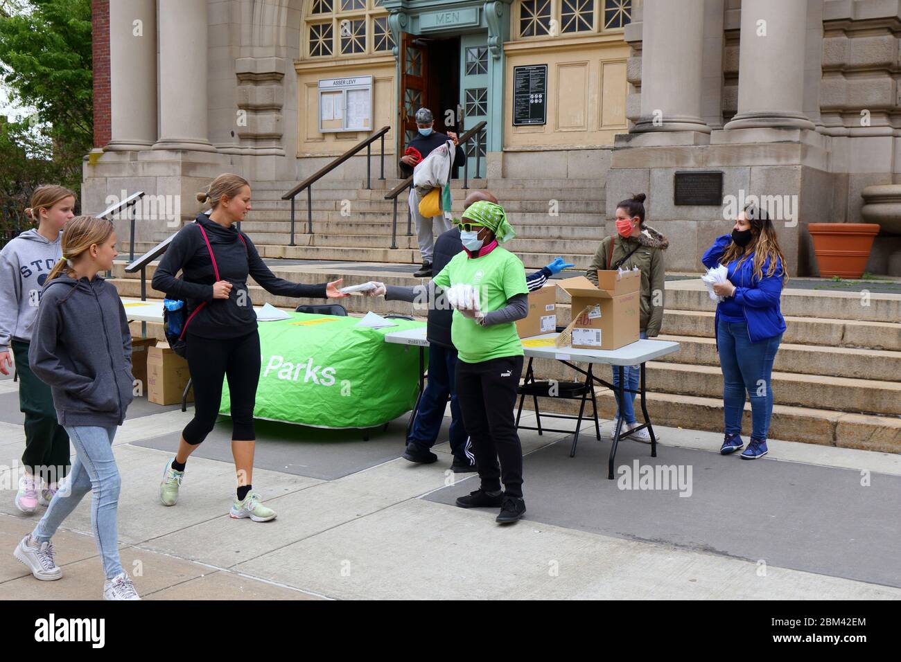 A NYC Parks Department staff member distributes free cloth face masks to people at Asser Levy Recreation Center... SEE MORE INFO FOR FULL CAPTION Stock Photo