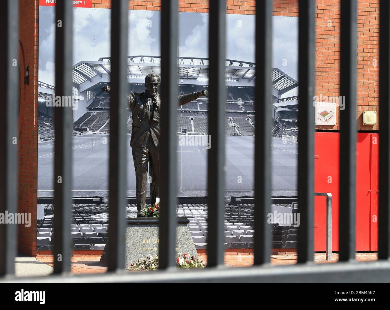 Liverpool, UK. 4th May, 2020. Anfield stadium during the suspension of the Premier League due to the Covid-19 virus pandemic; the statue of former manager Bill Shankly behind the padlocked gates of the Kop entrance Credit: Action Plus Sports/Alamy Live News Stock Photo