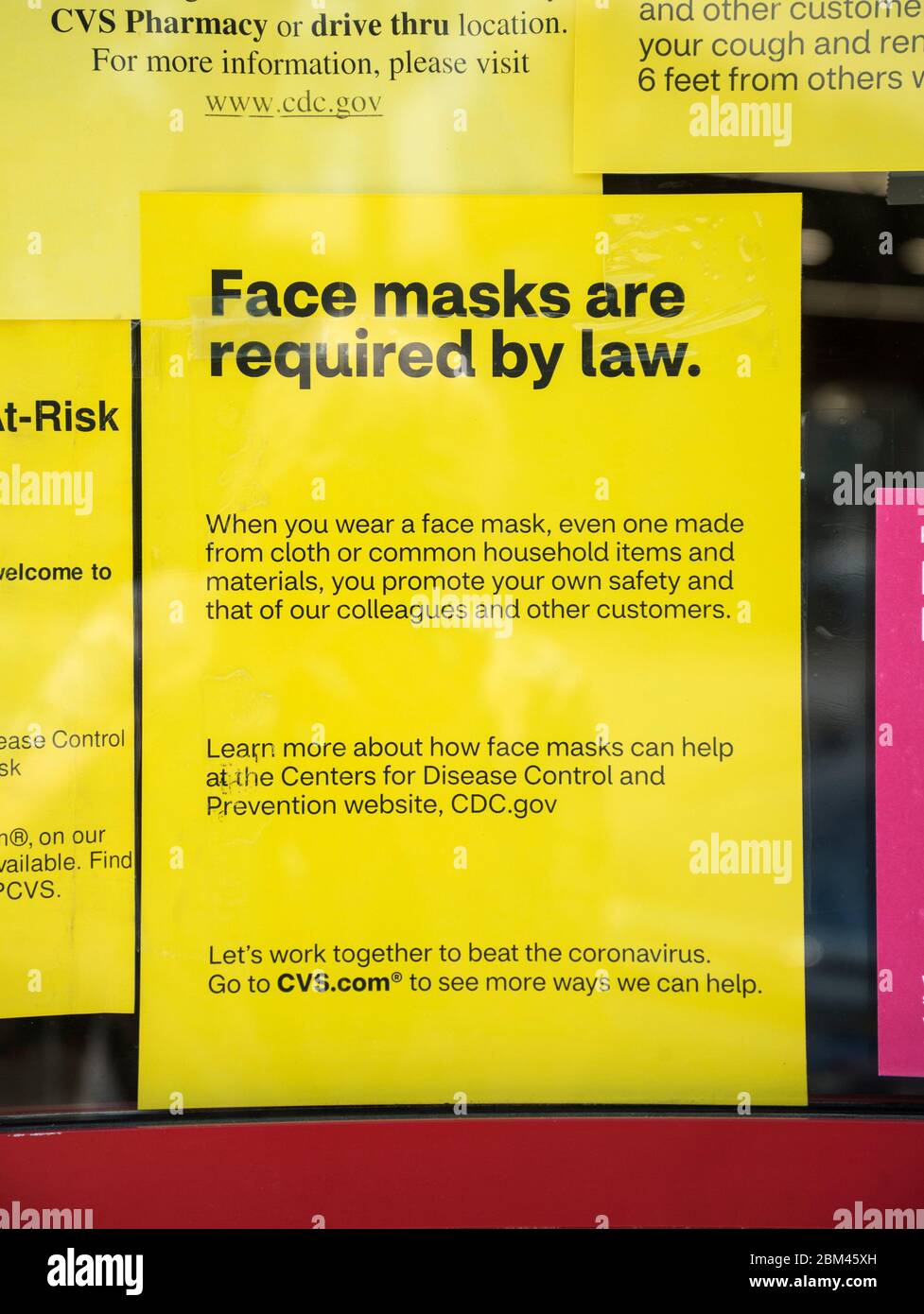 Mandated Face masks required by law in Alachua County, Florida by everyone who enters due to Covid 19 pandemic...Sign on pharmacy door entrance. Stock Photo