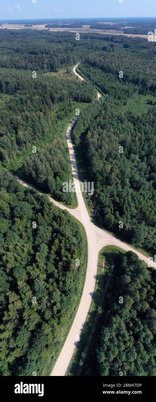 Summer time gravel road in forest, aerial view, vertical pano Stock Photo